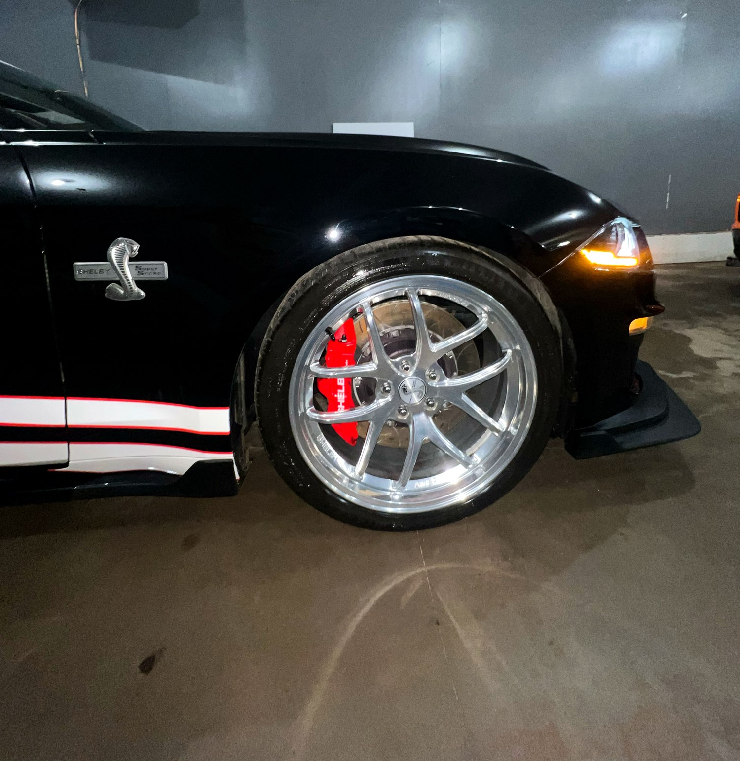 Shelby wheel with professional tire dressing, wheel cleaning, and paint reflection after detailing