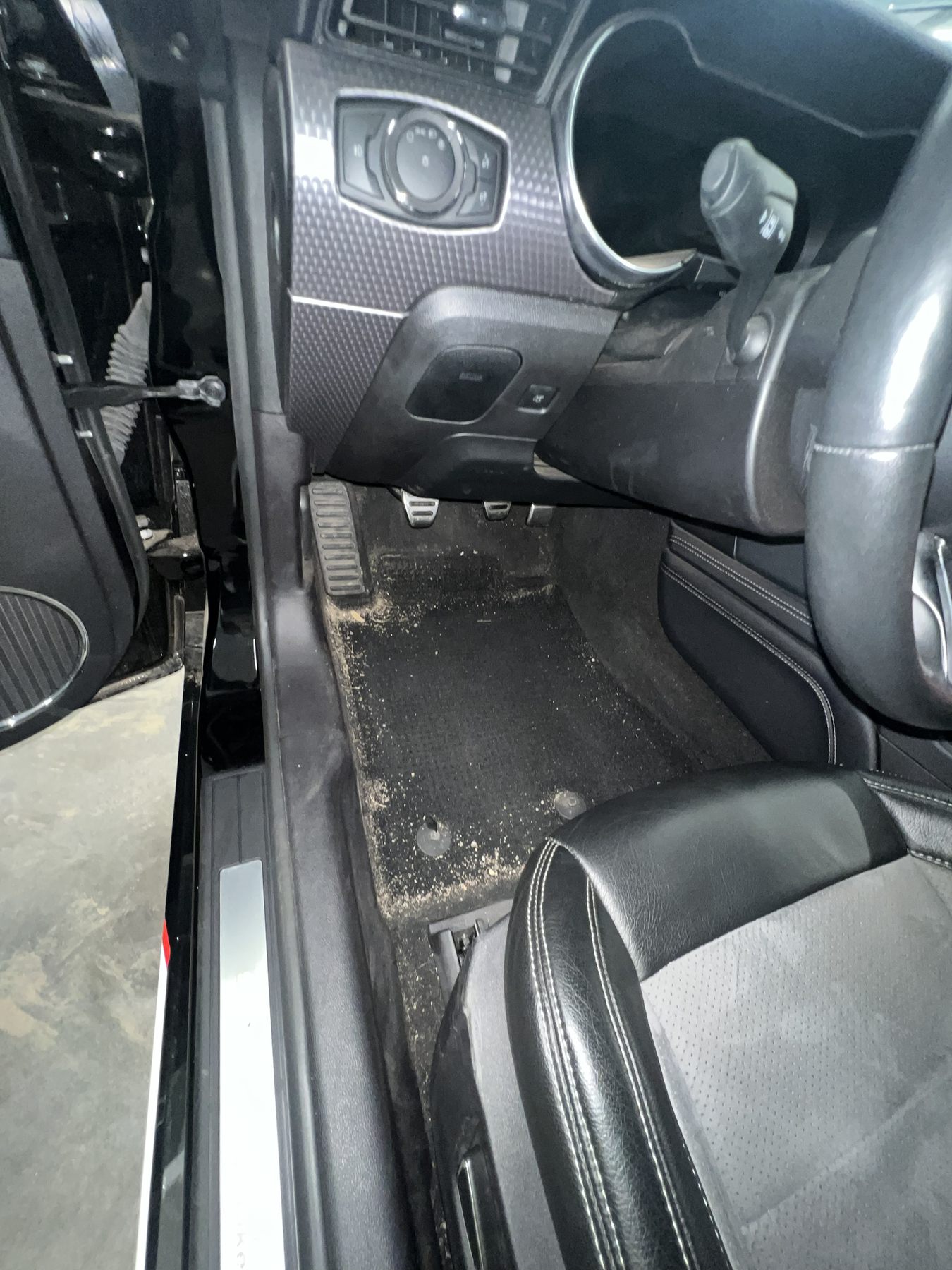 Dirty driver footwell before interior detailing